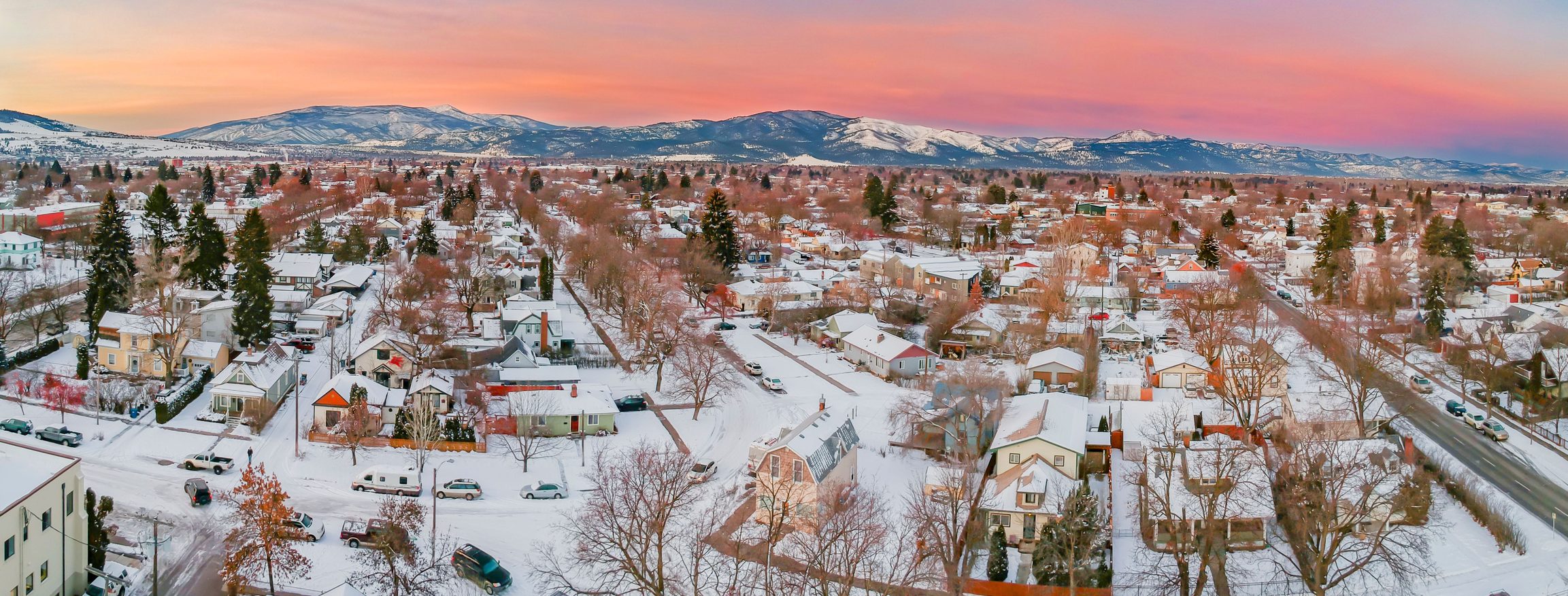 An aerial view of snow covered cityscape Missoula during sunset.