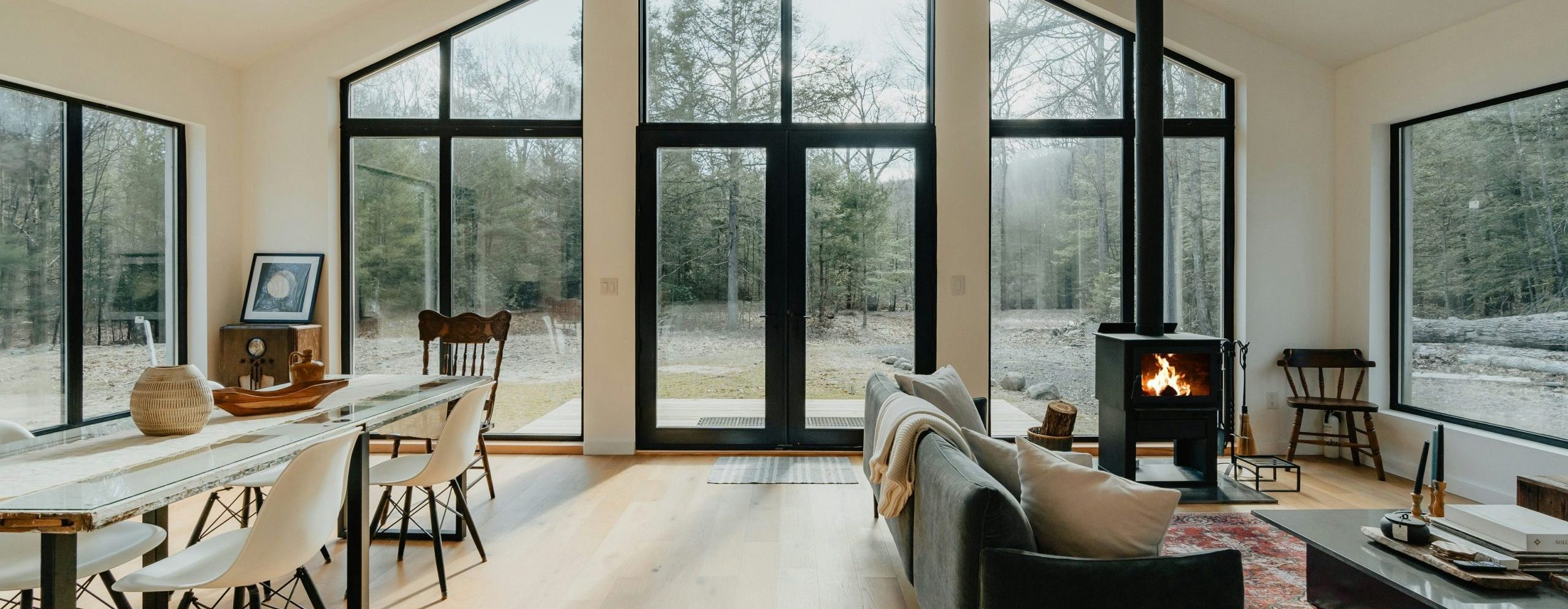 Interior shot of a cozy home, looking out to forest trees.