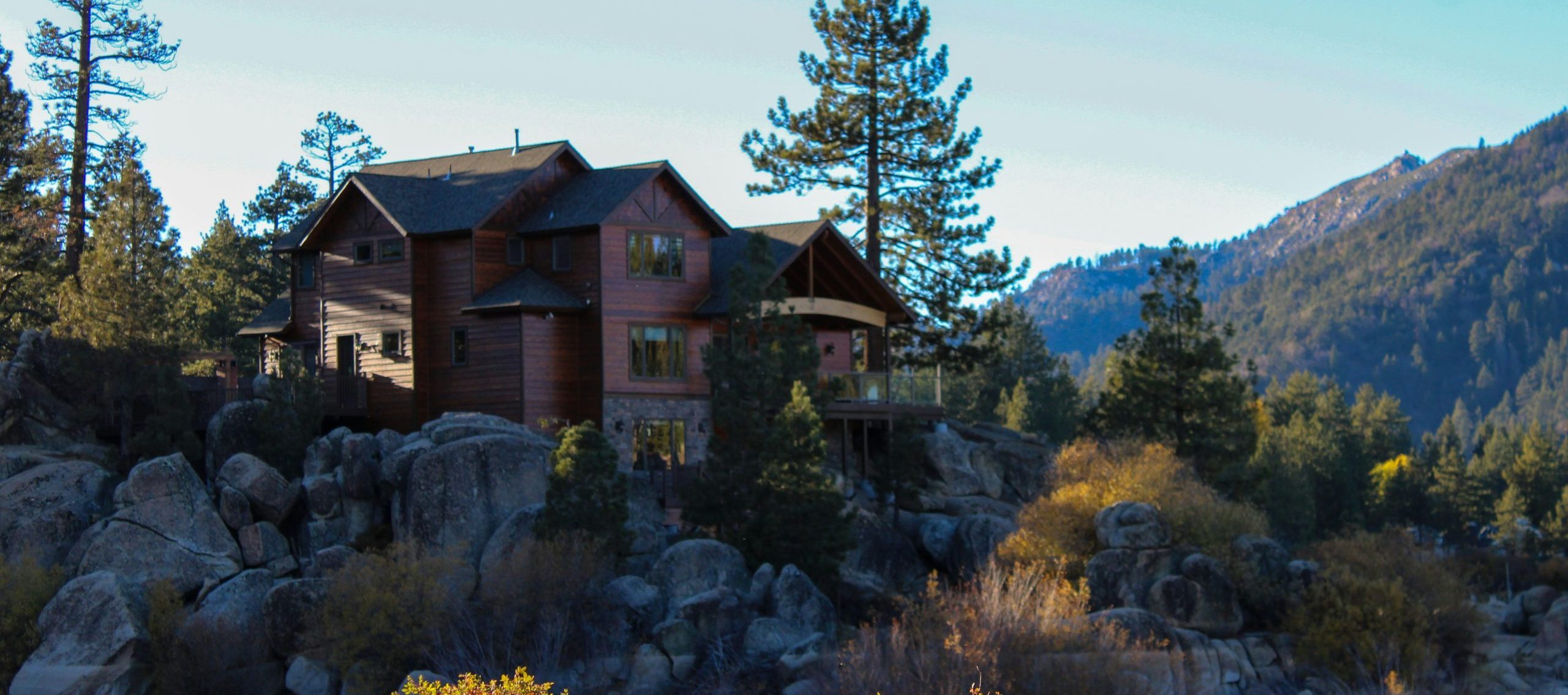 Nice home up high on rocks near water, isolated and beautiful on a sunny day.