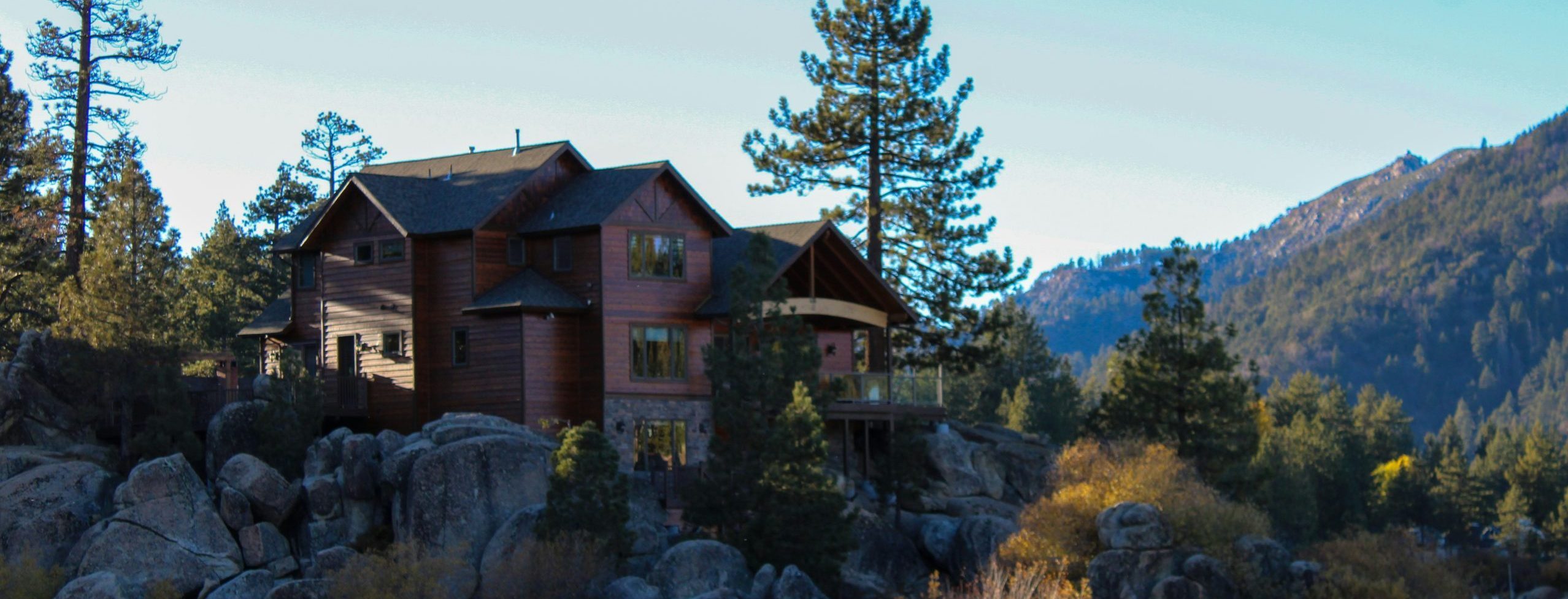 Nice home up high on rocks near water, isolated and beautiful on a sunny day.